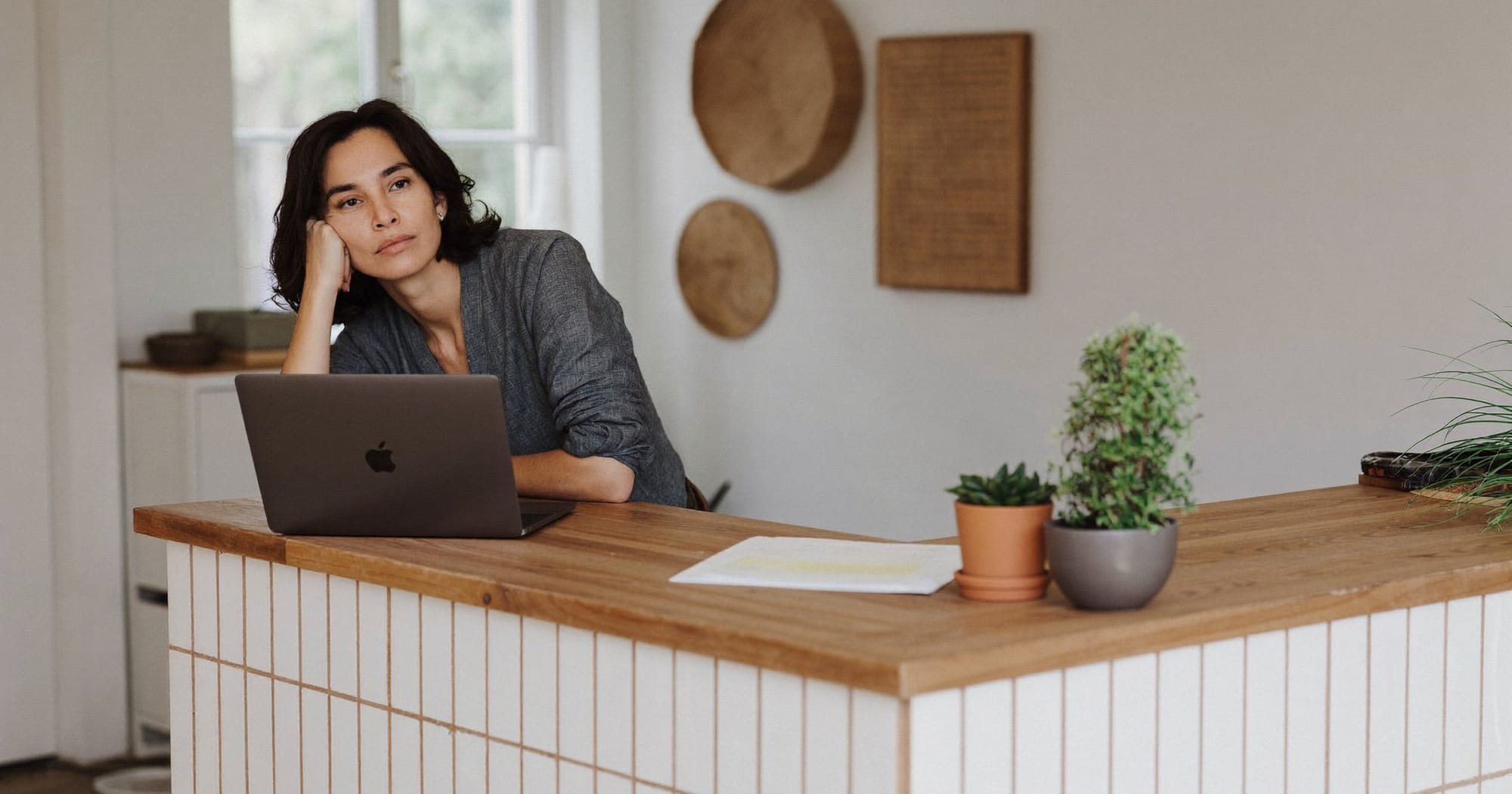 Liten-bedriftseier sitter med laptop i et lyst, moderne lokale